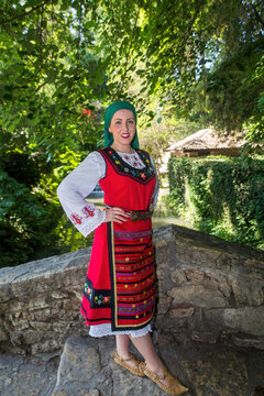 The beauty of the Bulgarian woman dressed in national costume in the sea garden of Balchik , Bulgaria.