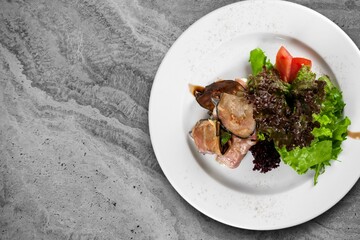 Grilled meat in marinated fillet with sauce and vegetable on the desk.