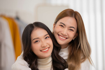 Happy LGBT lesbian couple lesbian embracing and looking together with love and romance on bed.