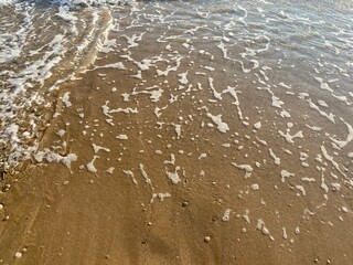 Top view of the sandy beach and waves