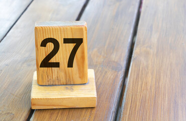 Wooden priority number 27 on a plank tab