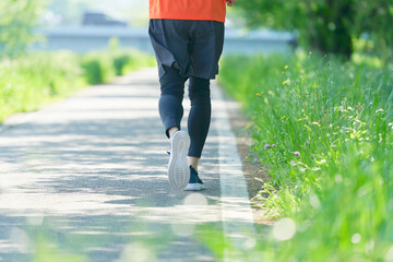 屋外をジョギングする男性の足元