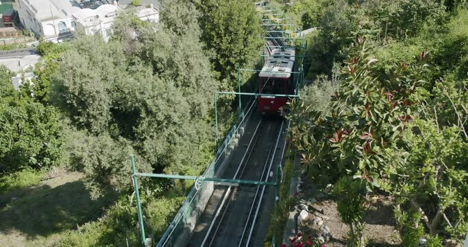 Top down shot of Capri's funicular while is arriving at the station of "La Piazzetta" in the city of Capri during a sunny mornin in spring