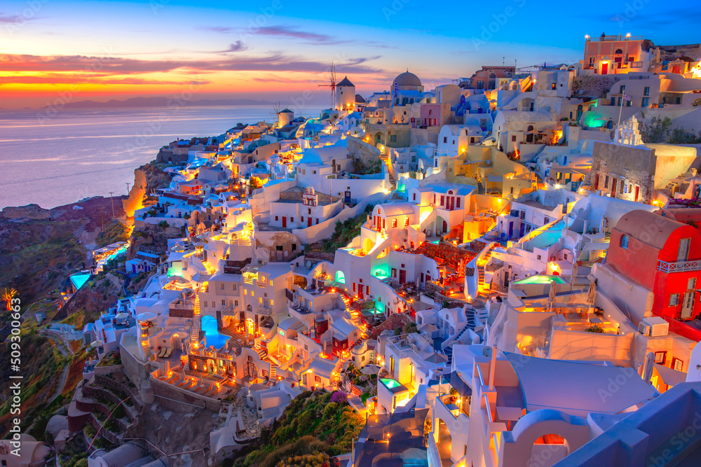 Wall mural Oia town on Santorini island, Greece. Traditional and famous houses and churches with blue domes over the Caldera, Aegean sea