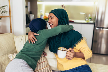 Happy muslim mother and daughter spending quality time together at home