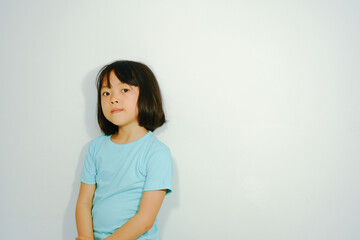 Photo background of an Asian girl wearing a blue shirt on white plaster.