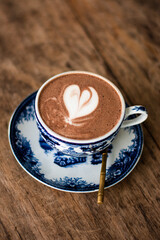 Hot chocolate with heart shape on the table brown wood.
