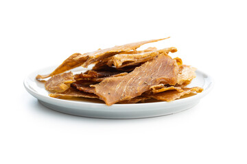 Turkey jerky meat on plate. Dried sliced meat isolated on white background.