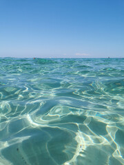 Crystal clear, blue, transparent water of the Mediterranean Sea on Sunrise beach.