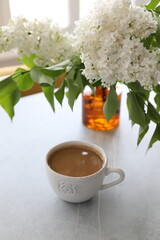 Bouquet of white lilacs in a yellow glass vase on the table