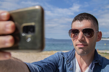 young man taking a selfie at the beach bar