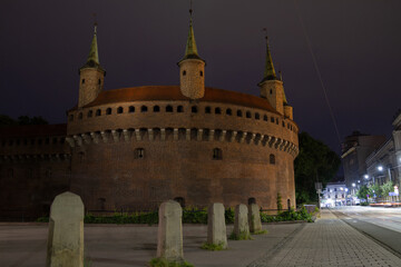 Kraków Barbican by night. Historic fortified gateway of the Old Town of Krakow, Poland.