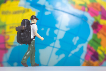 Miniature People Traveler with backpack on The Globe background