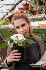 Beautiful european woman - owner of greenhouse houseplant and flowers nursery