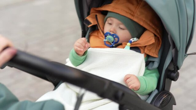 Portrait of little 11 month old baby sitting in a stroller.