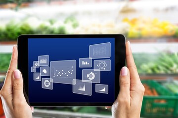 Retail management. Worker hands holding tablet on blurred supermarket background