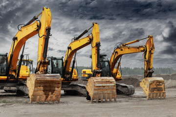 Powerful excavators at a construction site against a blue cloudy sky. Earthmoving construction...
