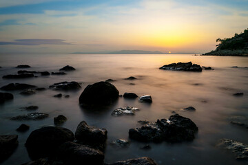Fototapeta na wymiar Long exposure photo of sea, rocks and sunset. Concept of relax, calm, tranquil and inner peace.