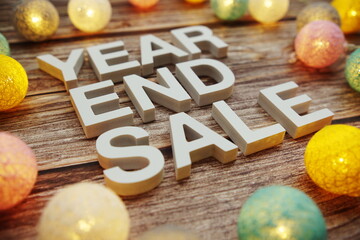 Year End Sale alphabet letters decorate with LED cotton balls on wooden background