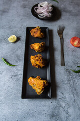 Pieces of meat kebabs served in a black tray on a background with use of selective focus