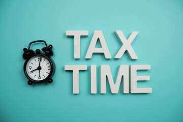 Tax Time alphabet letters with alarm clock on blue background