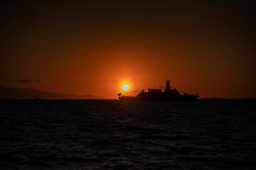 Fototapeta premium Izmir. Silhouette of a warship on the background of the sunset over the Aegean Sea