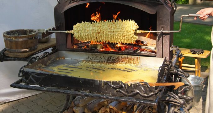 Palanga, Litva - June 04 2022: The traditional Lithuanian pie Shakotis is baked on an open fire.