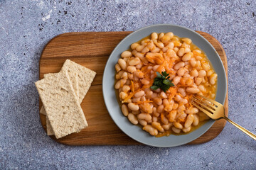 Stewed beans with vegetables on a plate top view