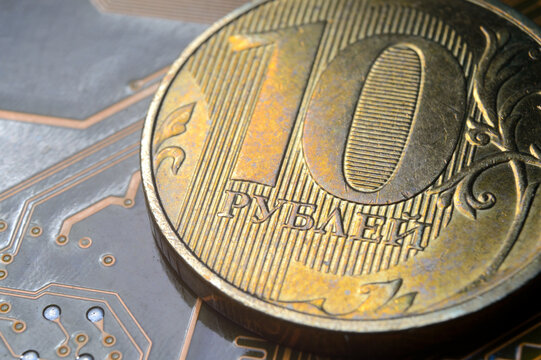 A coin with a face value of 10 rubles lies on a microcircuit. close-up. Translation of the inscription on the coin: "10 rubles" The concept of the digital economy in the Russian Federation