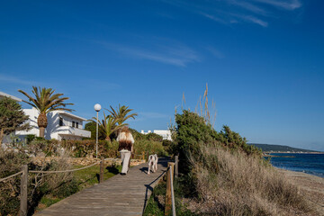 Migjorn beach, Racó Fondo , woman walking on a catwalk, Formentera, Pitiusas Islands, Balearic...