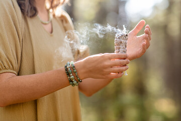 occult science and supernatural concept - close up of woman or witch with smoking white sage...