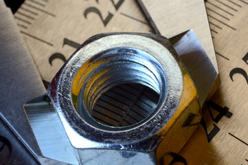 Accurate measuring tool caliper and metal ruler lie in place with nuts. close-up.