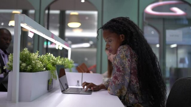 Afro woman using tablet computer in cafe steadicam shot