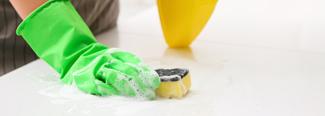 Woman cleaning table with sponge and detergent, closeup