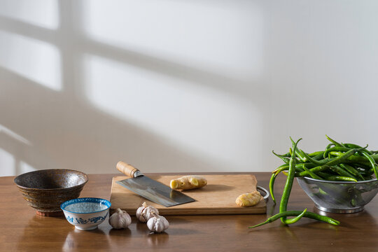 The peppers, garlic, ginger and other spices on the desktop and kitchen utensils and tableware