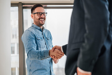 Happy businessmen shaking hands for successful deal at meeting