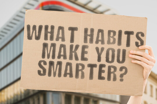 The question " What habits make you smarter? " is on a banner in men's hands with blurred background. Smart. Task. Wellness. Smarter. Productive. Effect. Habits. Use. Sad. Skill. Advice. Tip. Work