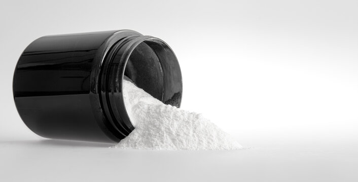 Measuring spoon and white medicinal powder with black jar