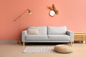 Comfortable sofa and stylish lamp near pink wall