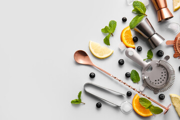 Cocktail ingredients and bartender kit on grey background