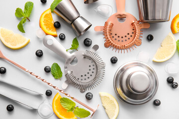 Set of bartender utensils and ingredients on grey background