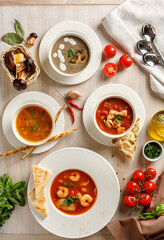 Overhead view of different types of soups on wooden background on wooden table