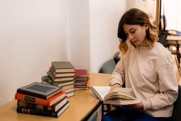 Girl reads a book in a library