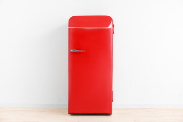 Stylish retro fridge near light wall in room