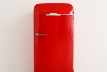 Stylish retro fridge near light wall in room