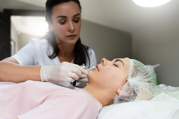 Obraz na płótnie Canvas Professional permanent makeup artist applying anesthetic cream