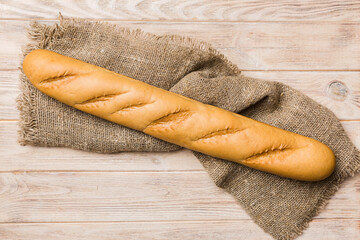 fresh crunchy french baguette on colored table. Top view Bakery products