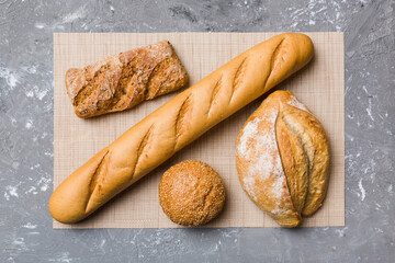 Assortment of freshly baked bread with napkin on rustic table top view. Healthy unleavened bread. French bread