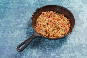 frying chopped tomatoes, onions, chilies, egg and barbequed brinjal together