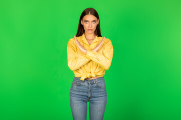 Serious Woman Gesturing Stop Crossing Hands Standing Over Green Background